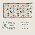 Tubie tape with a repeating Halloween pattern of cartoon ghosts, pumpkins, bats, candy corn, and stars on a pale lavender background, shown with text below reading 'CUT TO ANY SHAPE' and 'SHEET SIZE W-10CM X H-20CM' on a light beige background.