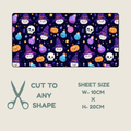 Tubie tape with a repeating Halloween pattern of cartoon skulls, witch hats, pumpkins, stars, and colorful bottles on a dark background, shown on a light beige backdrop. Text below reads 'CUT TO ANY SHAPE' with scissors icon, and 'SHEET SIZE W-10CM x H-20CM'.