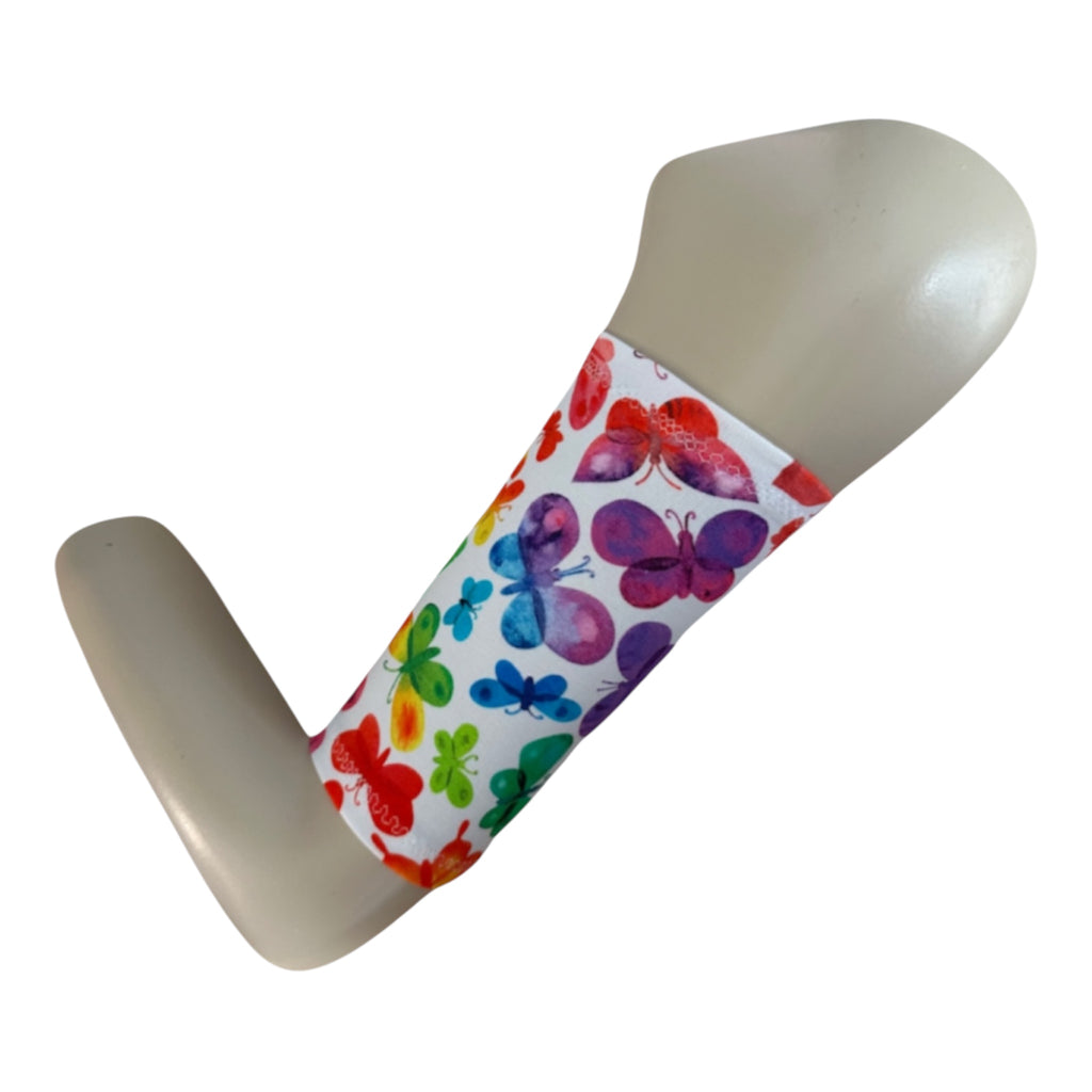 A white picc line cover with multicolour butterfly print. Armband is displayed on a manequinn arm. 