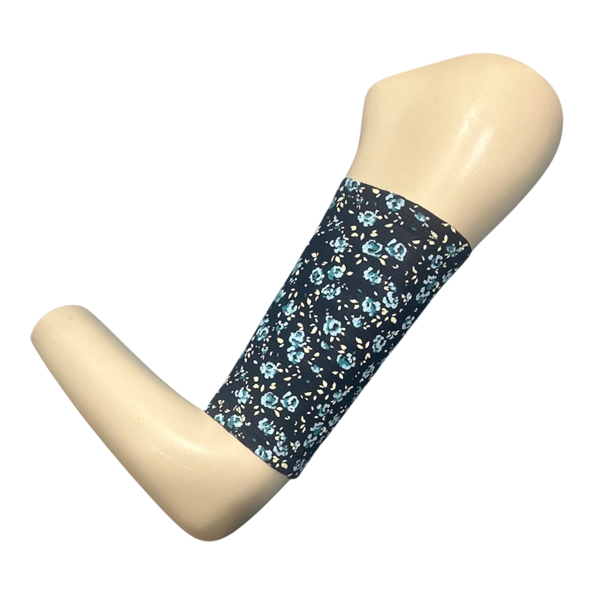 A navy blue picc line cover with a pale blue ose floral print. Armband is displayed on a manquinn arm