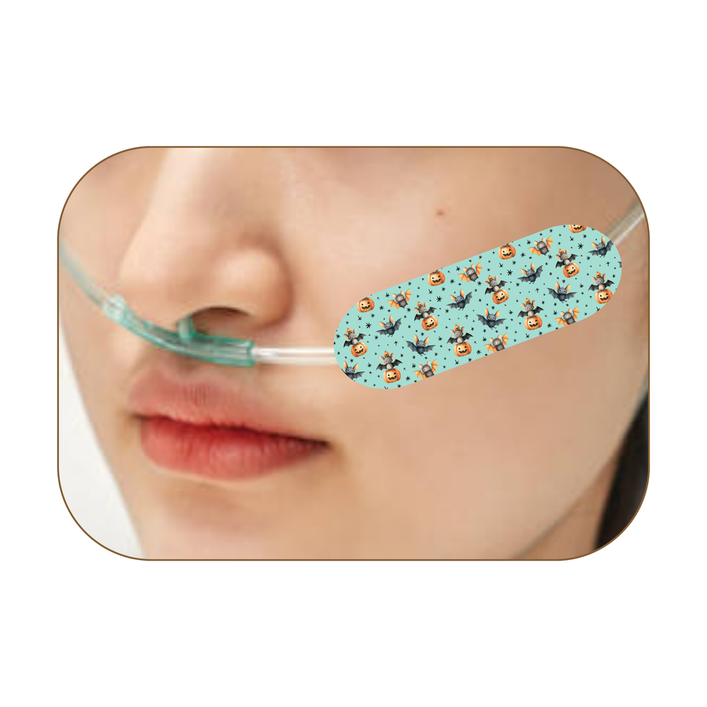 A close-up of a person's nose and lips wearing a light blue nasal adhesive patch with a repeating pattern of bats , pumpkin  and stars with a clear plastic nasal tube extending from the nose.